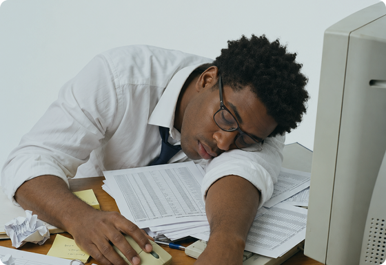 Exhausted property finance professional asleep on a pile of budget spreadsheets